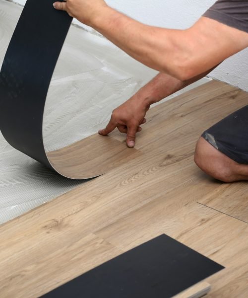 Worker installing new vinyl tile floor